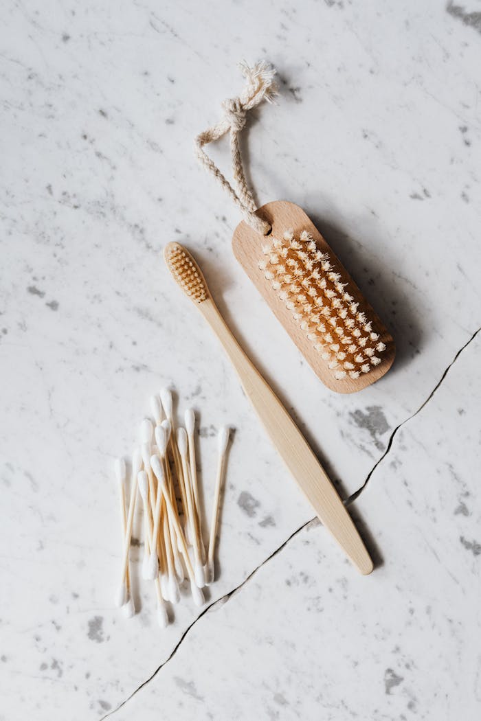 services-03 Top view layout of wooden cleaning brush and cotton swab placed on marble surface near wooden toothbrush on line chop